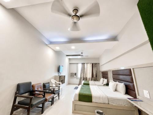 a hospital room with two beds and chairs at Hotel SVD HARIDWAR in Haridwār