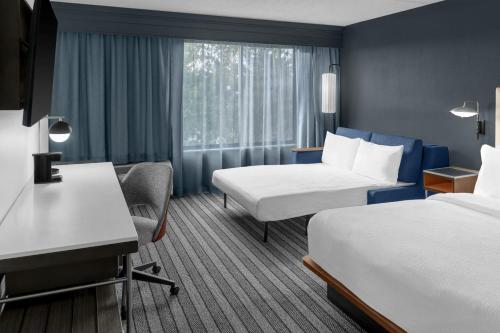 a hotel room with two beds and a window at Courtyard by Marriott Flint Grand Blanc in Flint