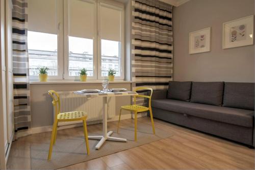 uma sala de estar com uma mesa e cadeiras e um sofá em Apartment I GrayFor2 Old Town Kraków em Cracóvia