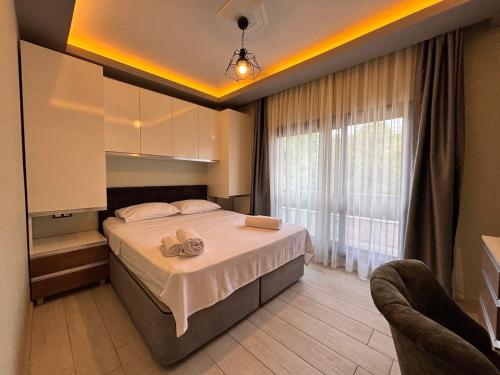 a bedroom with a bed with two towels on it at Easy Stay Mia Suites in Aydın