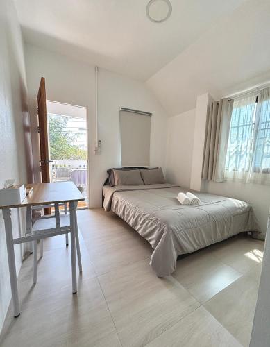 a bedroom with a bed and a desk in it at D sleep Home Chiangmai in Chiang Mai