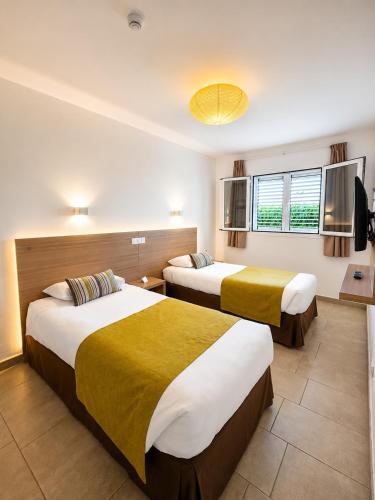 a hotel room with two beds and a window at Alsol Los Leones Bungalows - Adults Only in Maspalomas
