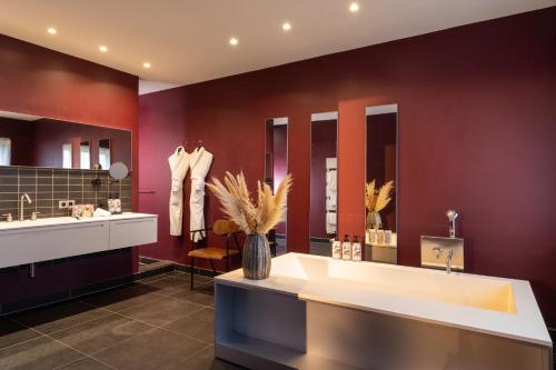 a bathroom with a large tub and a large mirror at Margaret - Hôtel Chouleur in Nîmes