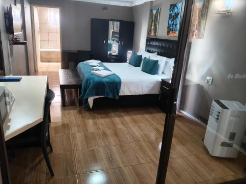 a hotel room with a bed and a table and a table sidx sidx at Blyde Lodge in Graskop
