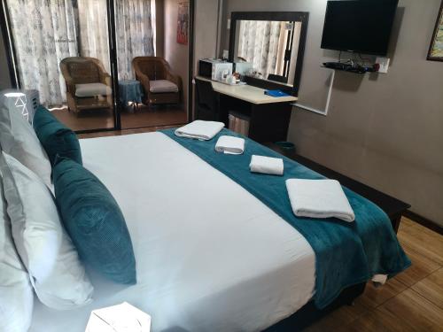 a large bed in a hotel room with two towels on it at Blyde Lodge in Graskop