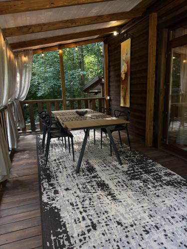 a table and chairs on the porch of a cabin at Садиба Володар in Kosiv