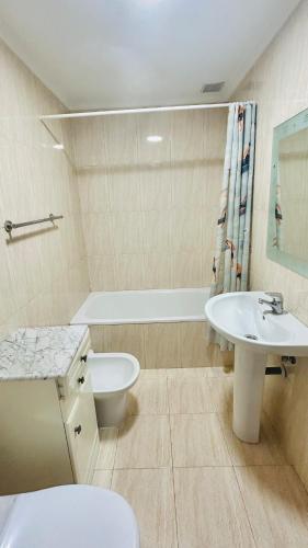 a bathroom with a sink and a toilet and a tub at Ocean Suances in Suances