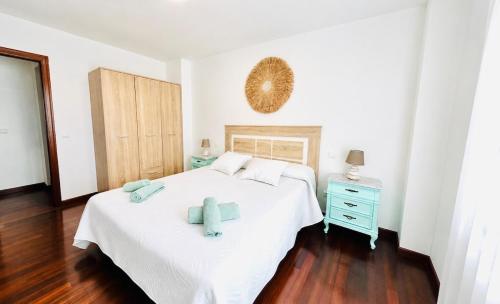 a bedroom with a white bed and a blue dresser at Ocean Suances in Suances