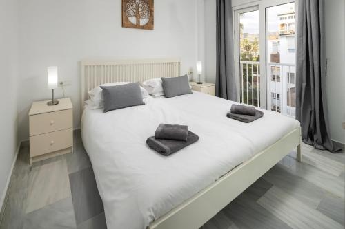 a white bed with two pillows on it in a bedroom at Beachfront Apt Torrox Costa in Torrox