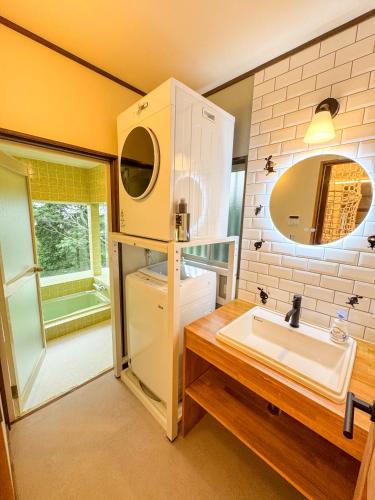 a bathroom with a sink and a mirror at Moro伊豆の国 in Izunokuni