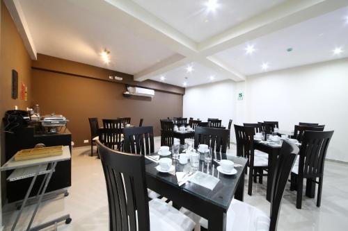 a dining room with black tables and black chairs at Hotel Solec in Chiclayo