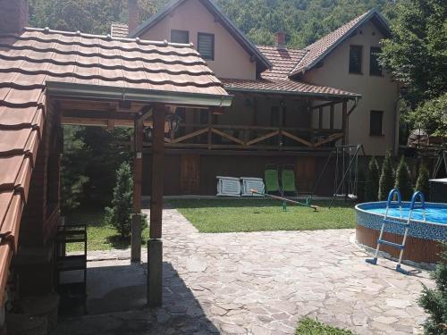 a backyard with a swimming pool and a house at Vila Žubor in Crni Vrh