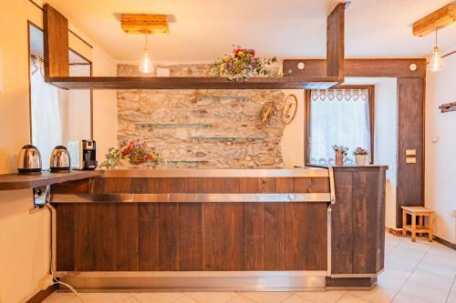 a kitchen with a counter and a stone wall at Meublé la Ciastella in Vinadio