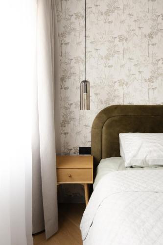 a bedroom with a bed with a wooden nightstand next to a bed sidx sidx at AN apartment 5 in Rēzekne