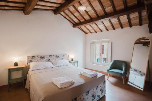 a bedroom with a bed and a chair and a mirror at B&B Lallabiló in San Clemente