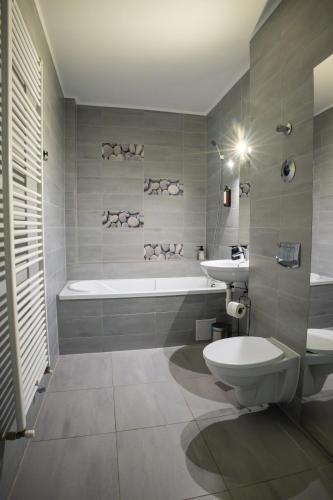 a bathroom with a tub and a toilet and a sink at Barrique 30 - Breakfast Delivered & Minibar - Free parking - Mall Area in Braşov