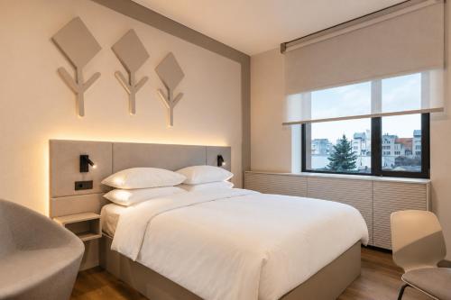 a bedroom with a large white bed and a window at Mimi Hotel Chisinau Jolly Alon in Chişinău