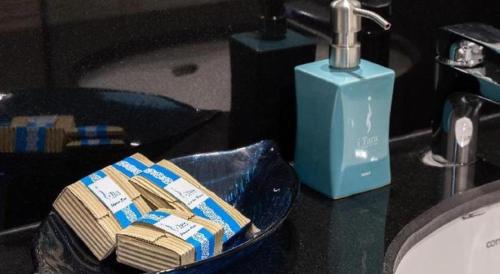 a bathroom counter with a sink and a blue bottle of soap at i Tara Private in Ban Laem Phak Bia (1)