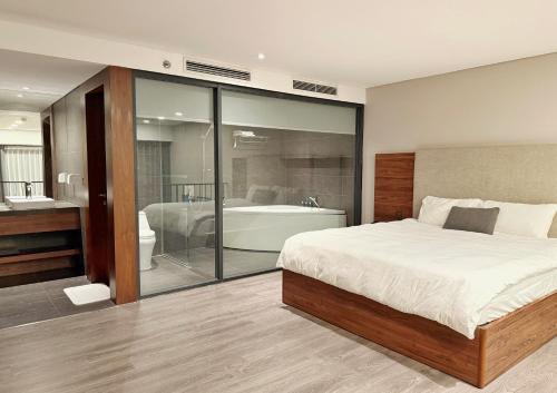 a bedroom with a bed and a tub and a bath room at PentStudio Westlake - Cozy Duplex - New Apartment in Hanoi