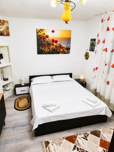 a bedroom with a white bed and a painting on the wall at Best view house in Orşova