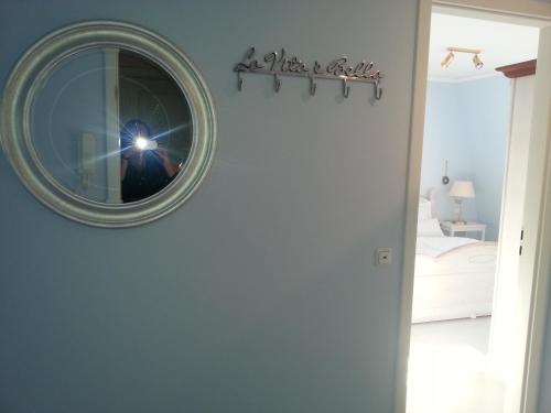 eine Person, die ein Bild von einem Spiegel an einer Wand macht in der Unterkunft Morgensünn am Strand in Kühlungsborn
