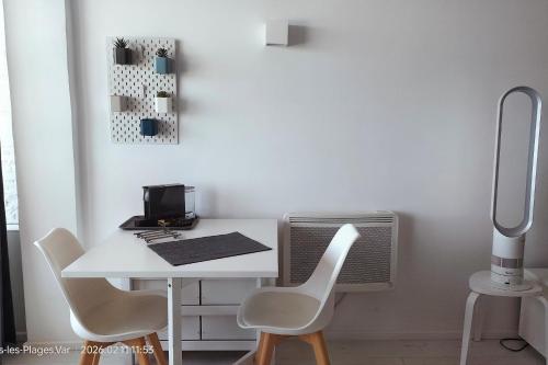a white table and chairs in a room at 27m with terrace - first row sea view in Six-Fours-les-Plages