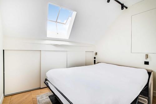 a white room with a bed and a window at Charming Studio 2P - Marais in Paris