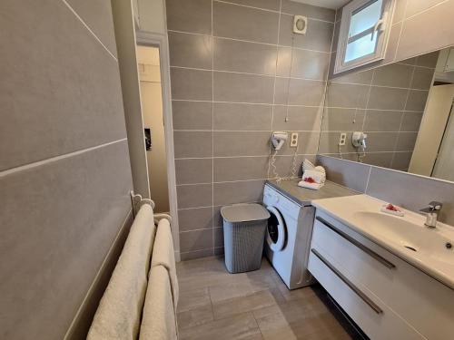 a bathroom with a washing machine and a sink at Studio Alizé 724 in Saint-François