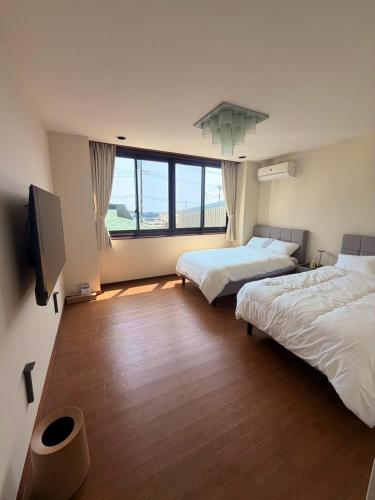 a room with two beds and a flat screen tv at Villa aco's in Ako