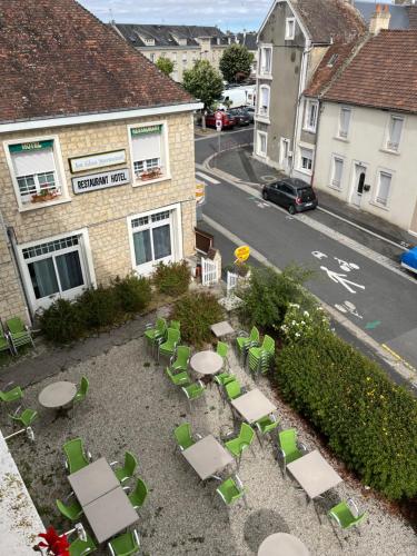 an outdoor patio with tables and chairs in front of a building at Le Clos Normand in Troarn