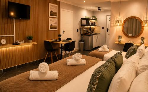 a hotel room with two beds with towels on them at Point Village Hotel and Self Catering in Mossel Bay