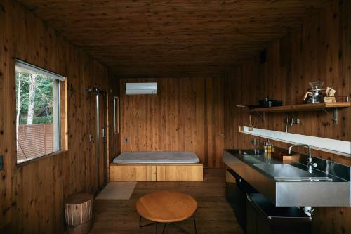 a kitchen with a sink and a bench in a room at Earthboat Ueda Onsen in Nagano