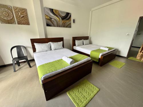 a bedroom with two beds and a chair at Prabhaz grand villa in Hatton
