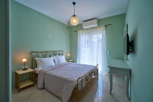 a bedroom with a bed and a desk and a window at Irida Home in Parga