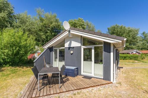 a tiny house with a deck and a table at Strandhaus Freibeuterweg 24 in Priwall