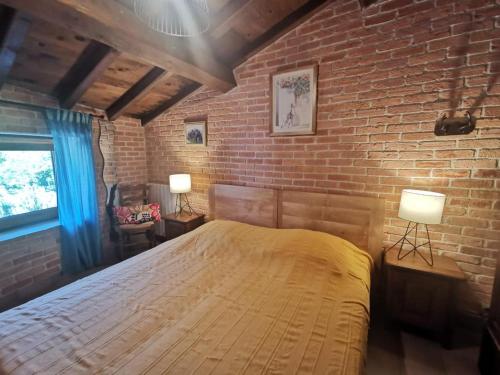a bedroom with a large bed in a brick wall at Côté séranne in Saint-André-de-Buèges