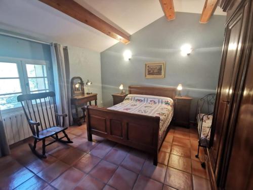 a bedroom with a bed and a chair in a room at Bergerie de la buèges in Saint-André-de-Buèges
