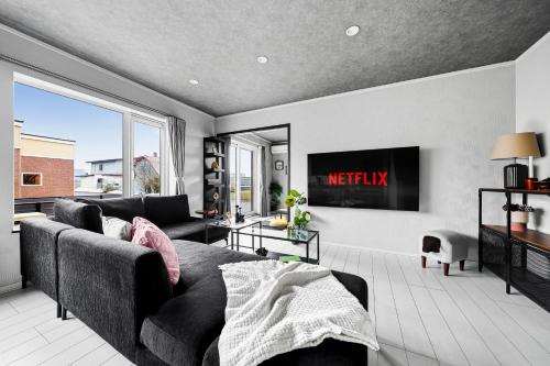 a living room with a couch and a tv at The Shelbourne Furano in Furano