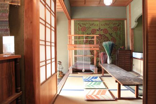 a room with a bench and a crib in it at Okayama Hostel Igusa in Hayashima