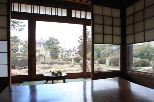 a room with a table and a large window at Okayama Hostel Igusa in Hayashima