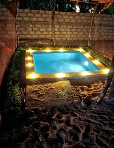 a swimming pool with lights around it at night at FR Resort in Pottuvil