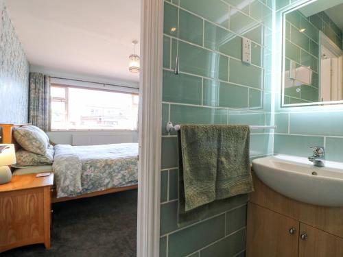 a bathroom with a bed and a sink and a tub at Pinecote Cottage in Nottingham