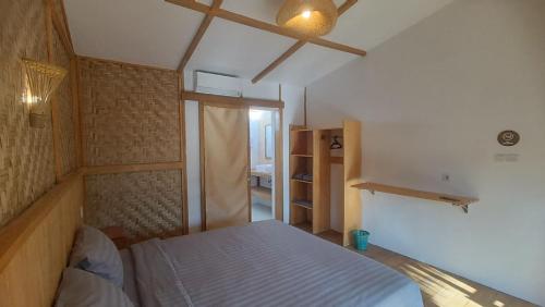 a small bedroom with a bed in a room at Morgans Bungalows in Maluk