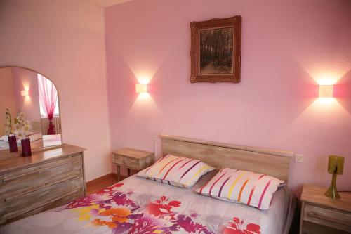 a bedroom with a bed with two pillows and a mirror at Au coeur du golfe in Sarzeau