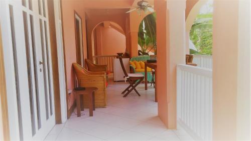 a hallway with chairs and a table in a room at Tobago Hibiscus Golf Villas & Appartments in Mount Irvine