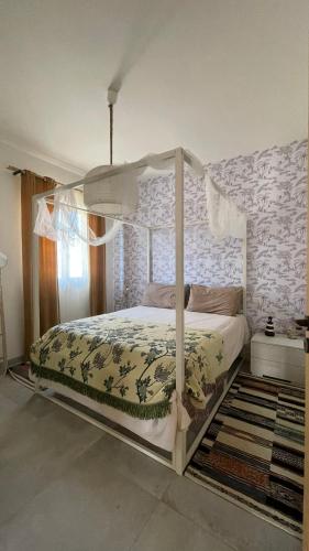 a bedroom with a bed with a canopy at Koru House Torvaianica in Torvaianica