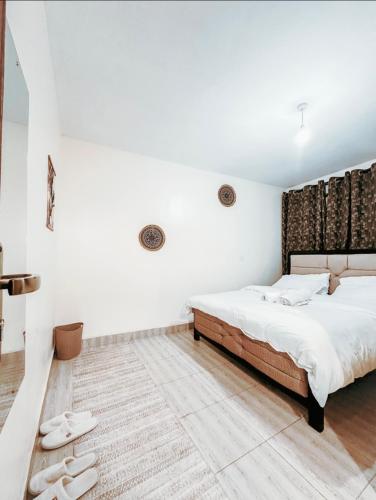 a bedroom with a large bed and white walls at Stylish Ngong Retreat with Balcony & Rooftop Lounge The Moon Stays in Ngong