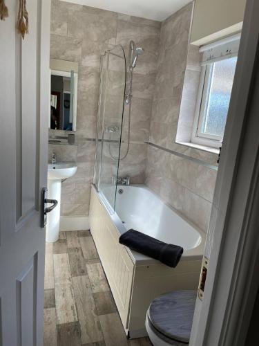 a bathroom with a tub and a shower and a toilet at 10 The Downs, Thurlestone overlooking Burgh Island in Kingsbridge