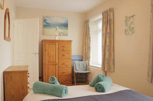 a bedroom with a bed and a dresser and a window at 10 The Downs, Thurlestone overlooking Burgh Island in Kingsbridge