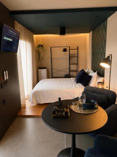a bedroom with a bed and a table in front of it at Isabelina Stays near Doñana & the Coast in Sanlúcar de Barrameda